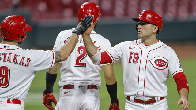 CINCINNATI, OH - SEPTEMBER 23: Mike Moustakas #9 and Joey Votto #19 of the Cincinnati Reds celebrate during the game against the Milwaukee Brewers at Great American Ball Park on September 23, 2020 in Cincinnati, Ohio.
