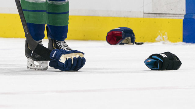 VANCOUVER, BC - FEBRUARY 22: A picks up a glove after a fight during NHL action between the Vancouver Canucks and the Boston Bruins at Rogers Arena on February 22, 2020 in Vancouver, Canada.
