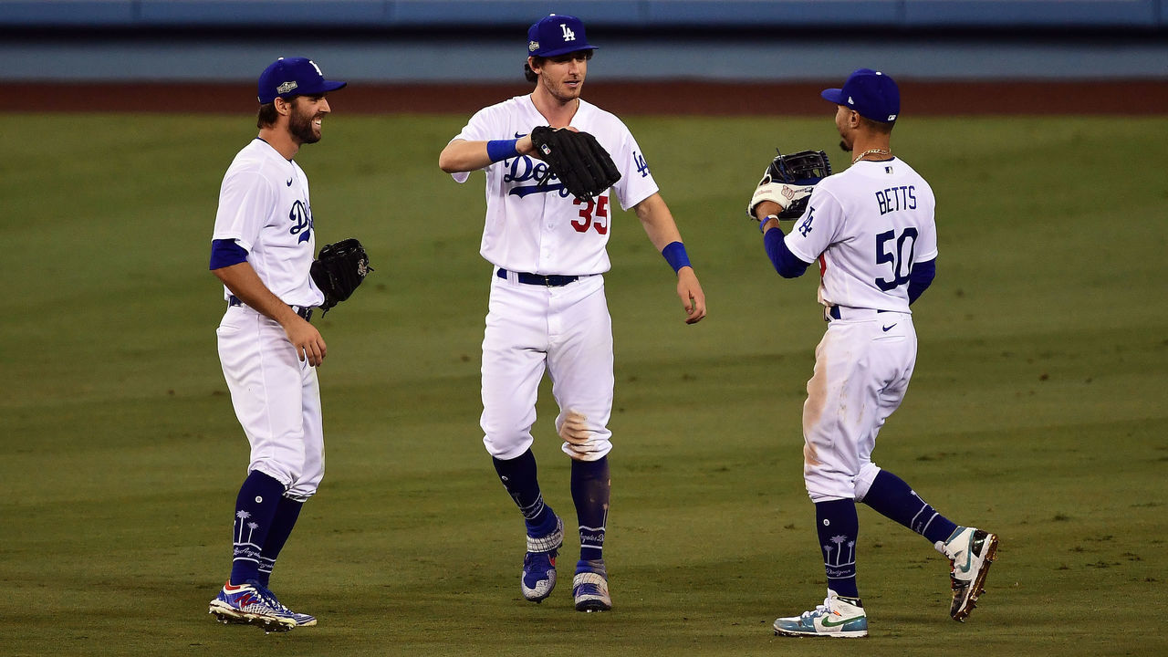 LOS ANGELES, CA - SEPTEMBER 30: Chris Taylor #3, Cody Bellinger #35, and Mookie Betts #50 of the Los Angeles Dodgers celebrate after winning Game 1 of the Wild Card Series 4-2 against the Milwaukee Brewers at Dodger Stadium on Wednesday, September 30, 2020 in Los Angeles, California.