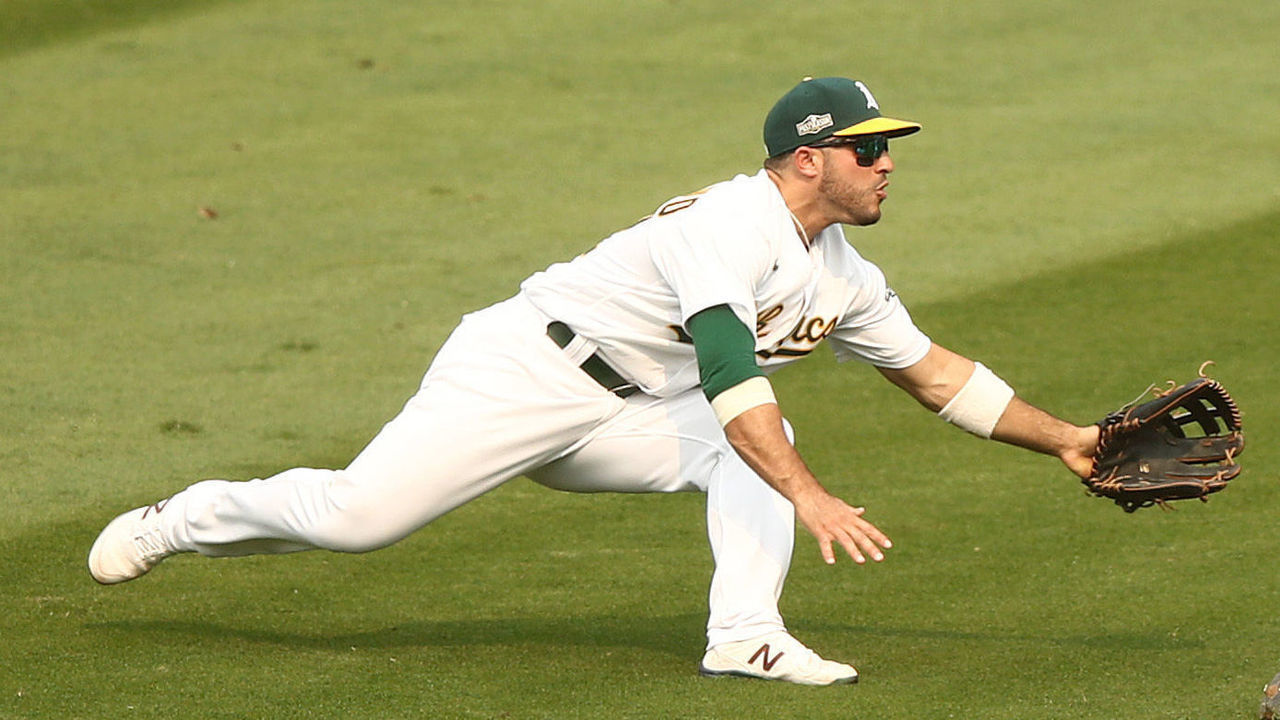 OAKLAND, CALIFORNIA - OCTOBER 01: Tommy La Stella #3 of the Oakland Athletics makes a great catch on a ball hit by Adam Engel #15 of the Chicago White Sox as Ramon Laureano #22 watches him in the fifth inning of Game Three of the American League wild card series at RingCentral Coliseum on October 01, 2020 in Oakland, California.