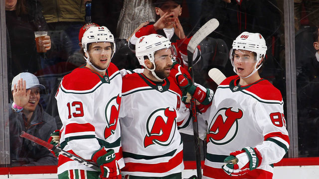 NEWARK, NJ - DECEMBER 20: Nico Hischier #13, Kyle Palmieri #21 and Jack Hughes #86 of the New Jersey Devils celebrate a goal by Palmieri during an NHL hockey game against the Washington Capitals on November 20, 2019 at the Prudential Center in Newark, New Jersey. Capitals won 6-3. Devils wore their 1980's heritage uniforms.