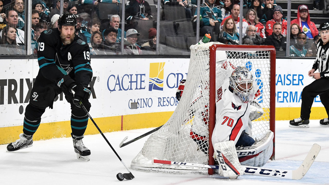 SAN JOSE, CA - FEBRUARY 14: Joe Thornton #19 of the San Jose Sharks skates with the puck behind Braden Holtby #70 of the Washington Capitals at SAP Center on February 14, 2019 in San Jose, California