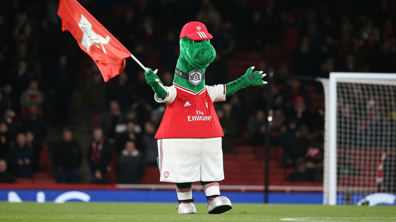 LONDON, ENGLAND - DECEMBER 05: Arsenal mascot Gunnersaurus waves a flag before the Premier League match between Arsenal FC and Brighton & Hove Albion at Emirates Stadium on December 5, 2019 in London, United Kingdom.