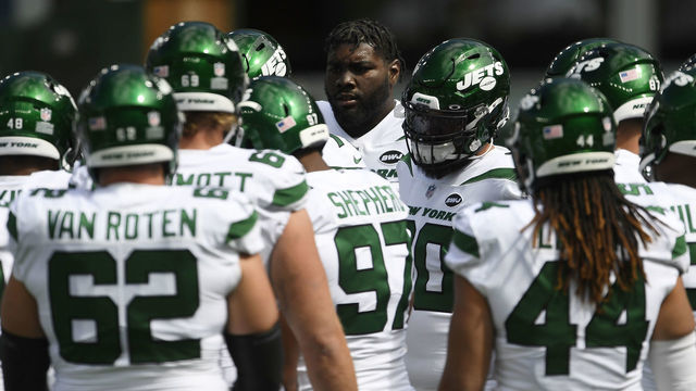 EAST RUTHERFORD, NEW JERSEY - SEPTEMBER 20: Mekhi Becton #77 of the New York Jets looks on in a huddle during warmups before the game against the San Francisco 49ers at MetLife Stadium on September 20, 2020 in East Rutherford, New Jersey.