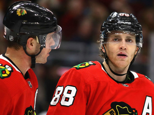 CHICAGO, ILLINOIS - DECEMBER 27: Jonathan Toews #19 of the Chicago Blackhawks talks with Patrick Kane #88 before a face-off against the New York Islanders at the United Center on December 27, 2019 in Chicago, Illinois. The Blackhawks defeated the Islanders 5-2.