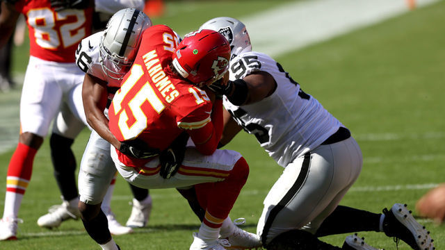 KANSAS CITY, MISSOURI - OCTOBER 11: Patrick Mahomes #15 of the Kansas City Chiefs is wrapped up by Datone Jones #95 and Nevin Lawson #26 of the Las Vegas Raiders during the third quarter at Arrowhead Stadium on October 11, 2020 in Kansas City, Missouri.