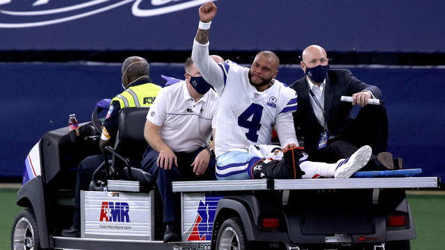 ARLINGTON, TEXAS - OCTOBER 11: Dak Prescott #4 of the Dallas Cowboys is carted off the field after sustaining a leg injury against the New York Giants during the third quarter at AT&T Stadium on October 11, 2020 in Arlington, Texas.