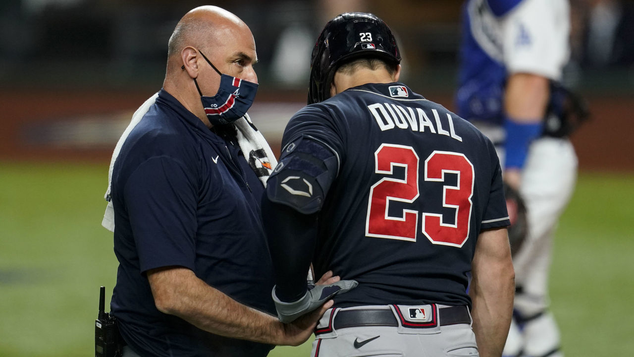ARLINGTON, TX - OCTOBER 12: Adam Duvall #23 of the Atlanta Braves receives medical attention after being hit by a ball during Game 1 of the NLCS between the Atlanta Braves and the Los Angeles Dodgers at Globe Life Field on Monday, October 12, 2020 in Arlington, Texas.