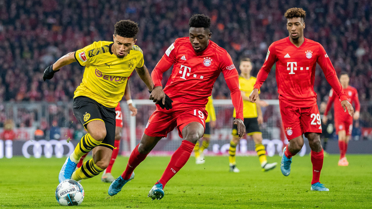 MUNICH, GERMANY - NOVEMBER 09: Jadon Sancho of Borussia Dortmund is challenged by Alphonso Davies of FC Bayern Muenchen and Kingsley Coman of FC Bayern Muenchen during the Bundesliga match between FC Bayern Muenchen and Borussia Dortmund at Allianz Arena on November 09, 2019 in Munich, Germany.