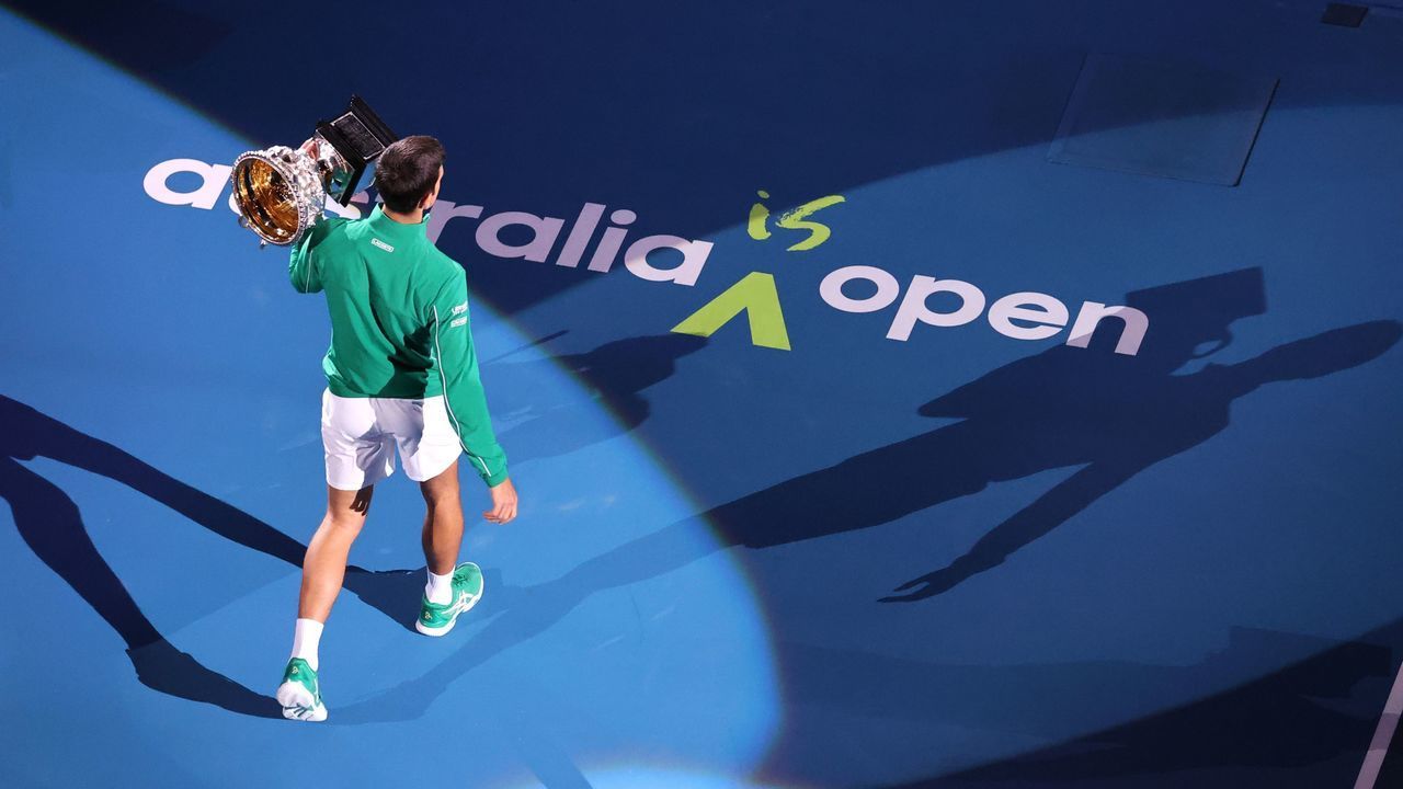 Serbia's Novak Djokovic holds the Norman Brooks Challenge Cup trophy after winning against Austria's Dominic Thiem in their men's singles final match on day fourteen of the Australian Open tennis tournament in Melbourne on February 3, 2020.