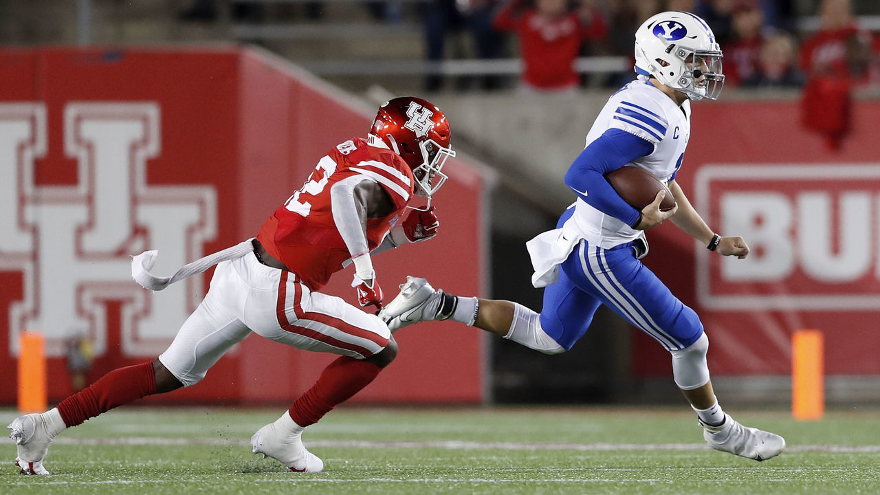 HOUSTON, TEXAS - OCTOBER 16: Zach Wilson #1 of the BYU Cougars scrambles past Gervarrius Owens #32 of the Houston Cougars in the first half at TDECU Stadium on October 16, 2020 in Houston, Texas.