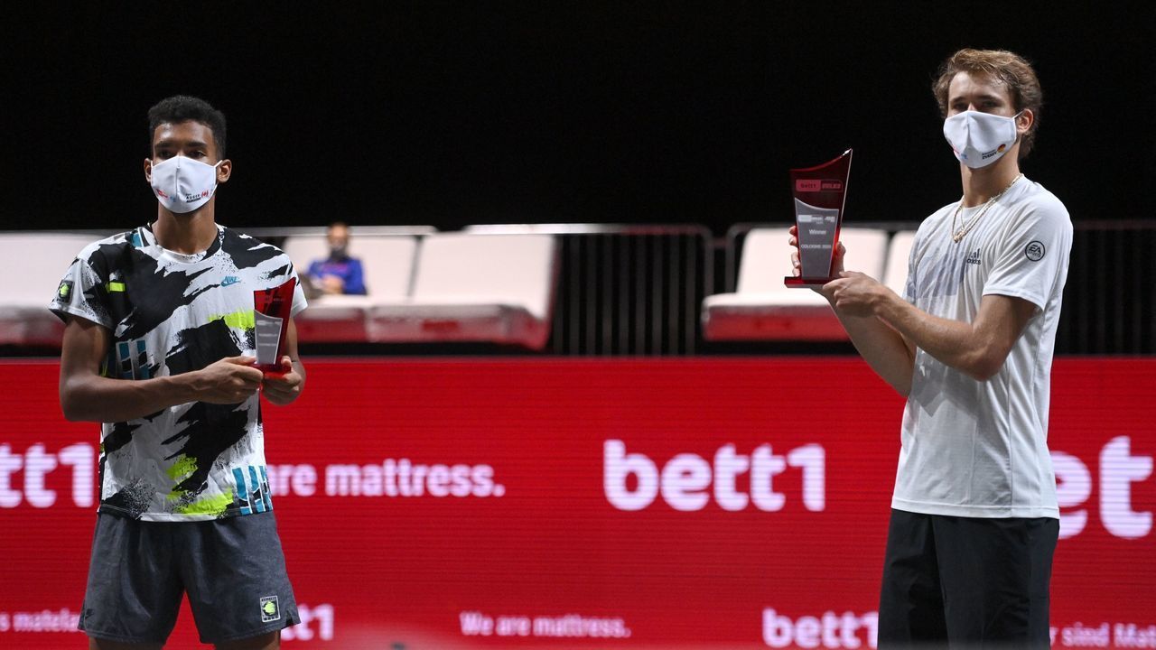 Winner Germany's Alexander Zverev and 2nd placed Canada's Felix Auger-Aliassime (L) celebrate with their trophies after the mens final of the 'Bett1Hulks Indoors' tennis tournament at the Lanxess Arena in Cologne, western Germany, on October 18, 2020.