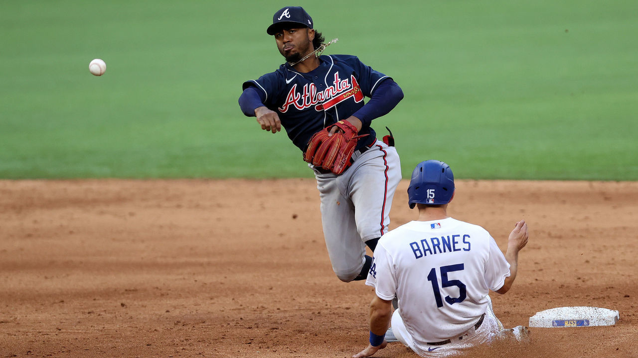 ARLINGTON, TEXAS - OCTOBER 17: Ozzie Albies #1 of the Atlanta Braves turns a double play against Austin Barnes #15 of the Los Angeles Dodgers during the sixth inning in Game Six of the National League Championship Series at Globe Life Field on October 17, 2020 in Arlington, Texas.