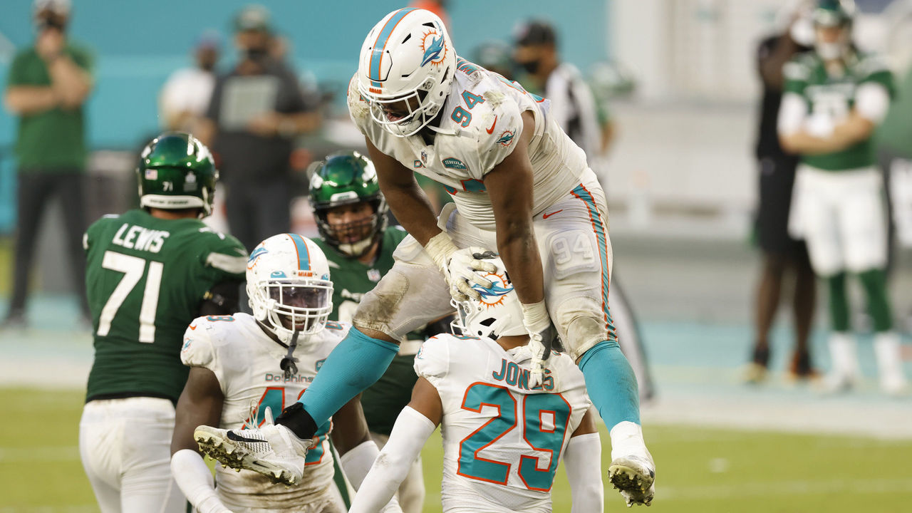 MIAMI GARDENS, FLORIDA - OCTOBER 18: Christian Wilkins #94 of the Miami Dolphins jumps over Brandon Jones #29 to celebrate after a defensive play that resulted in a loss of yardage for the New York Jets in the second half of their game at Hard Rock Stadium on October 18, 2020 in Miami Gardens, Florida.