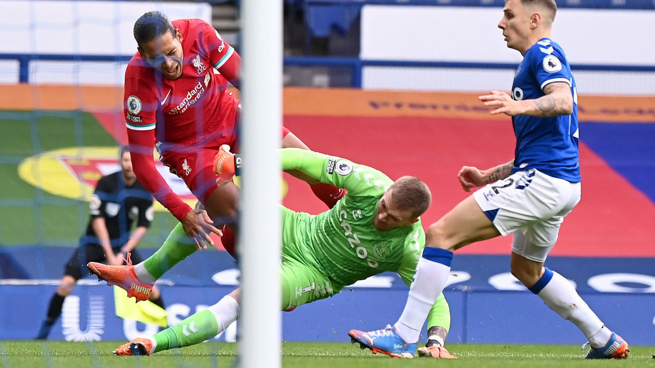 LIVERPOOL, ENGLAND - OCTOBER 17: Virgil van Dijk of Liverpool is tackled by Jordan Pickford of Everton which led to Virgil van Dijk being substituted for an injury during the Premier League match between Everton and Liverpool at Goodison Park on October 17, 2020 in Liverpool, England. Sporting stadiums around the UK remain under strict restrictions due to the Coronavirus Pandemic as Government social distancing laws prohibit fans inside venues resulting in games being played behind closed doors.