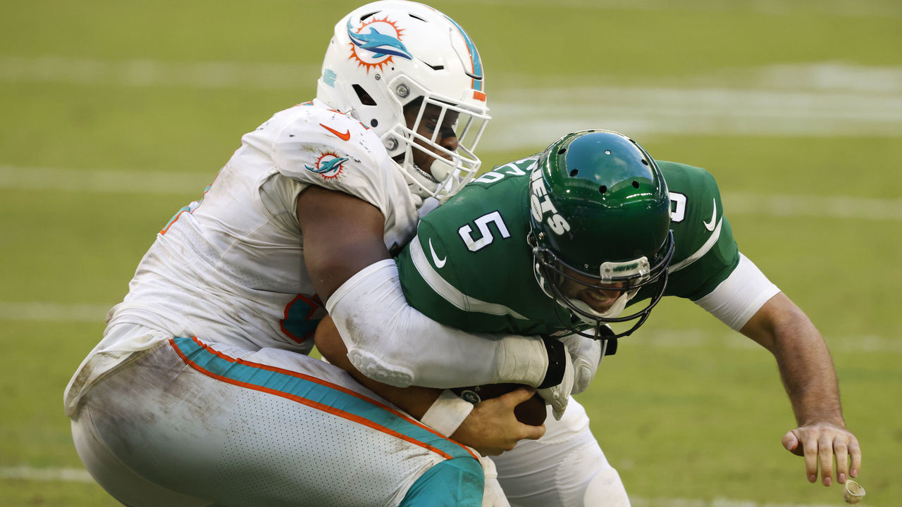 MIAMI GARDENS, FLORIDA - OCTOBER 18: Emmanuel Ogbah #91 of the Miami Dolphins tackles quarterback Joe Flacco #5 of the New York Jets for the sack during the second half of their game at Hard Rock Stadium on October 18, 2020 in Miami Gardens, Florida.