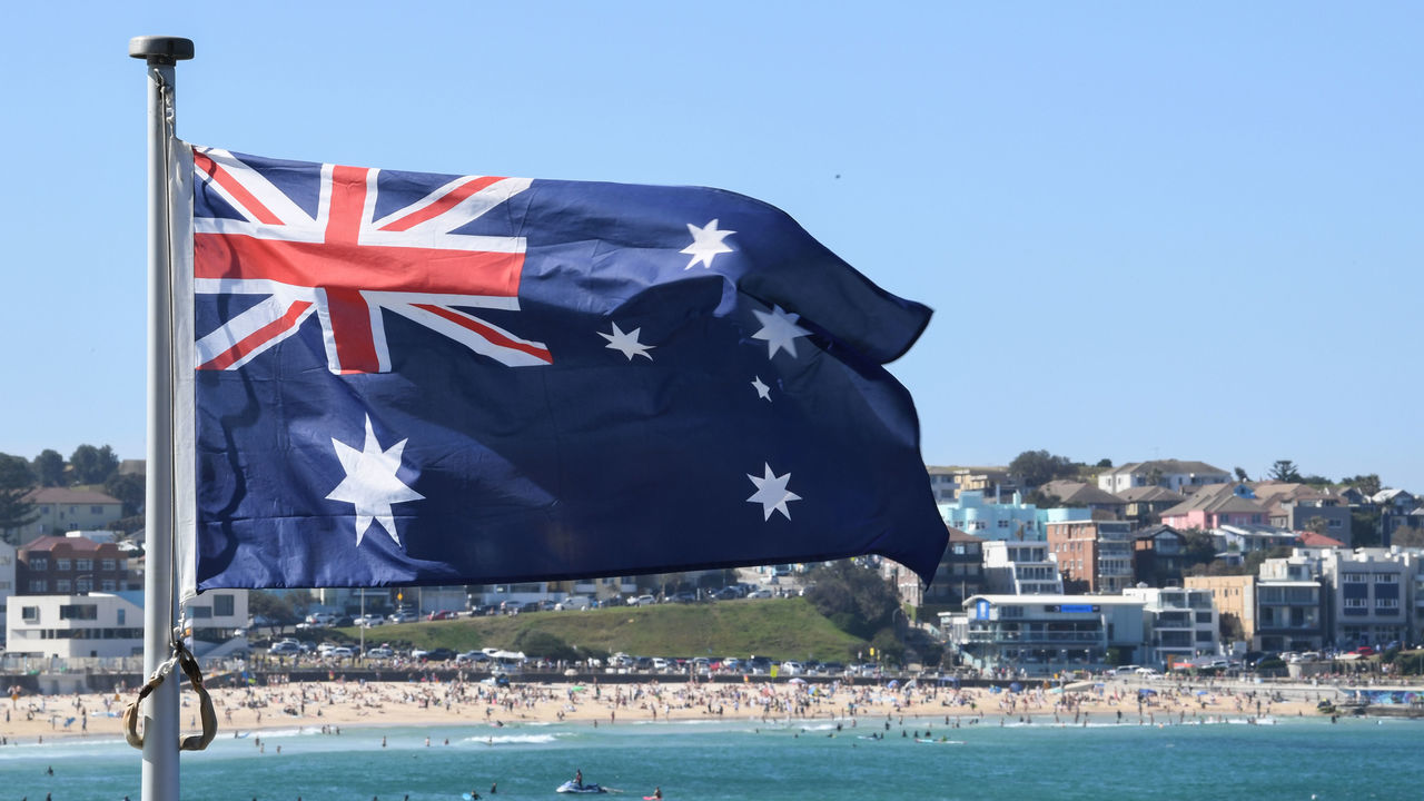 SYDNEY, AUSTRALIA - AUGUST 30: An Australian flag flies at Icebergs pool at Bondi Beach on August 30, 2020 in Sydney, Australia. Warm winter weather is being enjoyed across the entire Sydney basin this weekend for the last few days of winter. A top temperature of 25 degrees celsius is forecast for Sunday, well ahead of the normal average temperature. Temperatures are forecast to fall back to normal on Monday, the last day of winter.