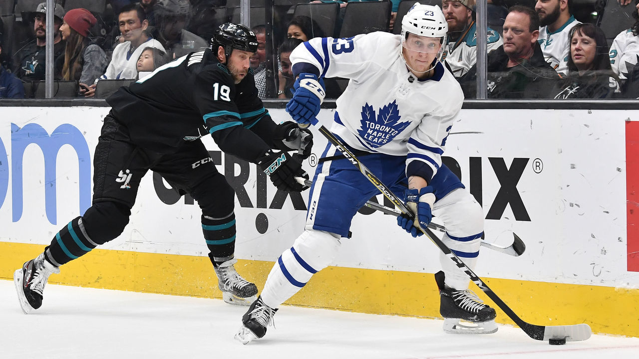 SAN JOSE, CA - NOVEMBER 15: (L-R) Joe Thornton #19 of the San Jose Sharks reaches for the puck from Travis Dermott #23 of the Toronto Maple Leafs at SAP Center on November 15, 2018 in San Jose, California