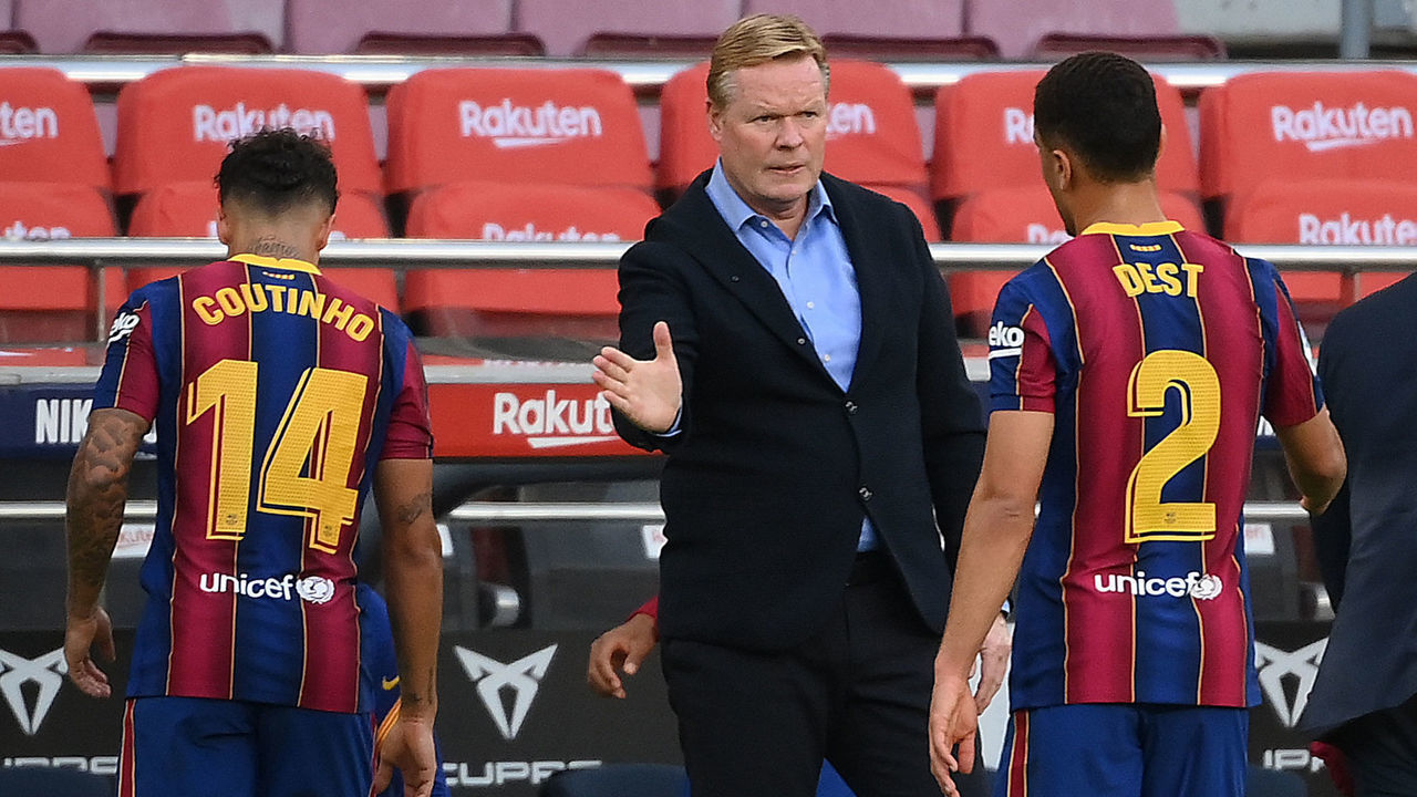 Barcelona's Dutch coach Ronald Koeman (C) consoles players at the end of the Spanish League football match between Barcelona and Real Madrid at the Camp Nou stadium in Barcelona on October 24, 2020.