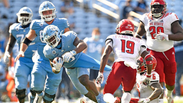 CHAPEL HILL, NORTH CAROLINA - OCTOBER 24: Jakeen Harris #6 of the North Carolina State Wolfpack grabs on to the jersey of Michael Carter #8 of the North Carolina Tar Heels during their game at Kenan Stadium on October 24, 2020 in Chapel Hill, North Carolina. The Tar Heels won 48-21.