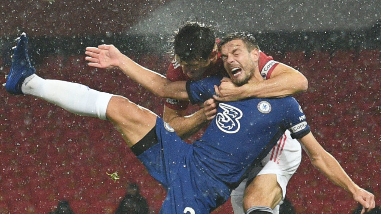 TOPSHOT - Manchester United's English defender Harry Maguire (L) challenges Chelsea's Spanish defender Cesar Azpilicueta (R) in the air during the English Premier League football match between Manchester United and Chelsea at Old Trafford in Manchester, north west England, on October 24, 2020.