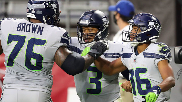 GLENDALE, ARIZONA - OCTOBER 25: Wide receiver Tyler Lockett #16 of the Seattle Seahawks is congratulated by offensive tackle Duane Brown #76 and quarterback Russell Wilson #3 after Lockett scored a receiving touchdown against the Arizona Cardinals in the first quarter of the game at State Farm Stadium on October 25, 2020 in Glendale, Arizona.