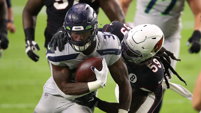 GLENDALE, ARIZONA - OCTOBER 25: Running back Chris Carson #32 of the Seattle Seahawks runs with the ball after a catch while being tackled by linebacker De'Vondre Campbell #59 of the Arizona Cardinals in the first quarter of the game at State Farm Stadium on October 25, 2020 in Glendale, Arizona.