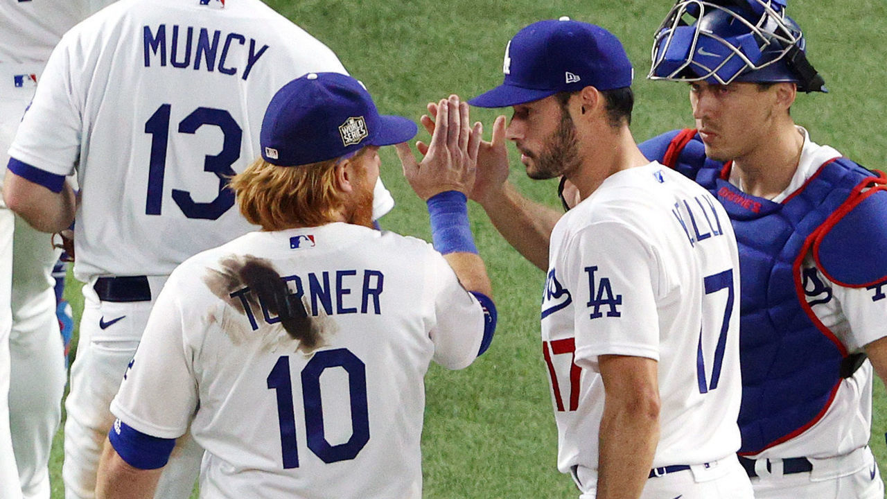 ARLINGTON, TEXAS - OCTOBER 20: Justin Turner #10, Joe Kelly #17 and Austin Barnes #15 of the Los Angeles Dodgers celebrate their teams 8-3 victory against the Tampa Bay Rays in Game One of the 2020 MLB World Series at Globe Life Field on October 20, 2020 in Arlington, Texas.