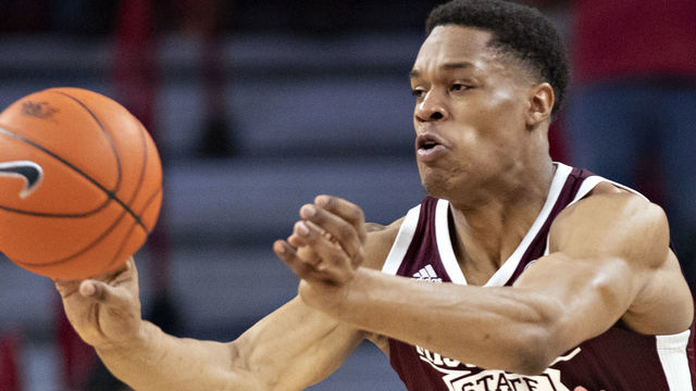 FAYETTEVILLE, AR - FEBRUARY 15: Robert Woodard II #12 of the Mississippi State Bulldogs makes a pass in the first half while being defended by Jimmy Whitt Jr. #33 of the Arkansas Razorbacks at Bud Walton Arena on February 15, 2020 in Fayetteville, Arkansas. The Bulldogs defeated the Razorbacks 78-77.