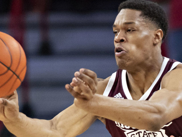 FAYETTEVILLE, AR - FEBRUARY 15: Robert Woodard II #12 of the Mississippi State Bulldogs makes a pass in the first half while being defended by Jimmy Whitt Jr. #33 of the Arkansas Razorbacks at Bud Walton Arena on February 15, 2020 in Fayetteville, Arkansas. The Bulldogs defeated the Razorbacks 78-77.