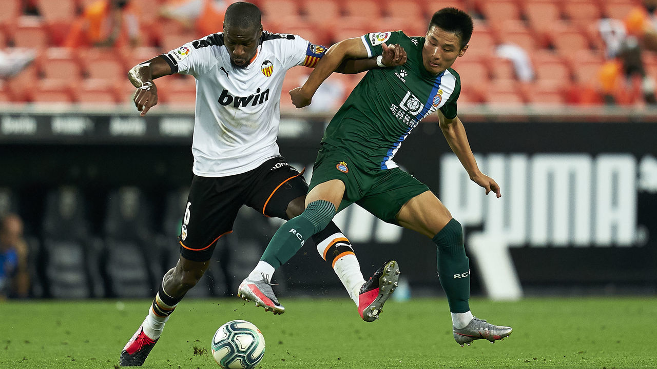 VALENCIA, SPAIN - JULY 16: Geoffrey Kondogbia of Valencia CF competes for the ball with Wu Lei of RCD Espanyol during the Liga match between Valencia CF and RCD Espanyol at Estadio Mestalla on July 16, 2020 in Valencia, Spain.
