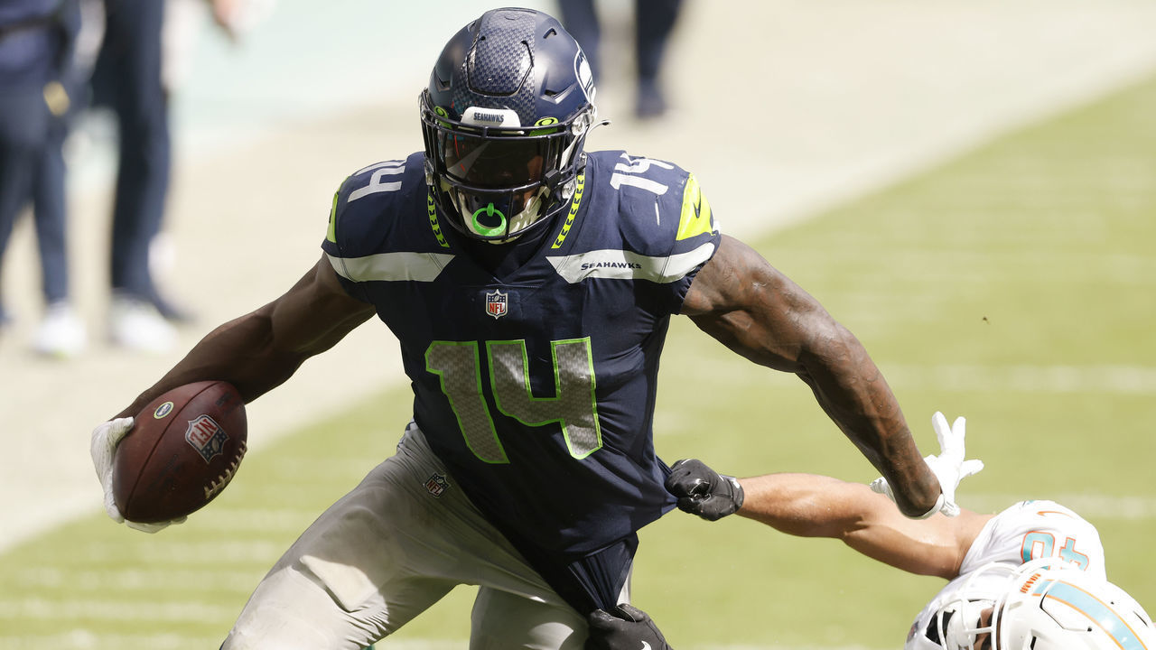 MIAMI GARDENS, FLORIDA - OCTOBER 04: DK Metcalf #14 of the Seattle Seahawks breaks a tackle from Nik Needham #40 of the Miami Dolphins during the fourth quarter at Hard Rock Stadium on October 04, 2020 in Miami Gardens, Florida.