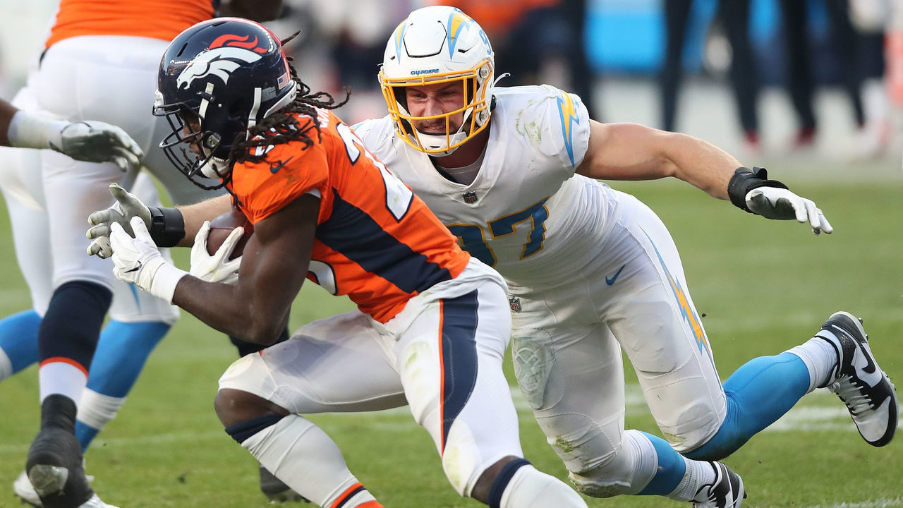 DENVER, COLORADO - NOVEMBER 01: Phillip Lindsay #30 of the Denver Broncos carries the ball against Joey Bosa #97 of the Los Angeles Chargers in the third quarter of the game at Empower Field At Mile High on November 01, 2020 in Denver, Colorado.