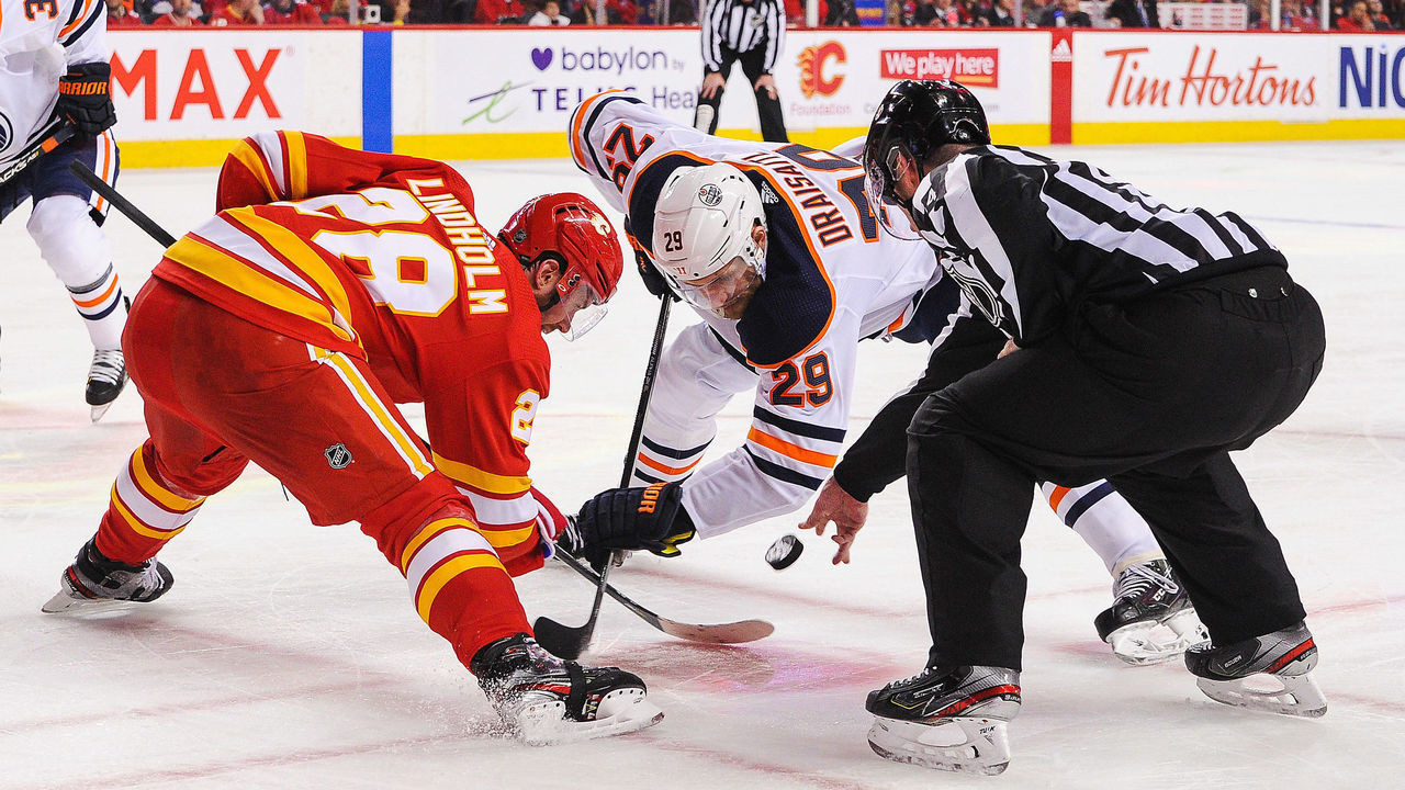 CALGARY, AB - FEBRUARY 1: Elias Lindholm #28 of the Calgary Flames faces-off against Leon Draisaitl #29 of the Edmonton Oilers during an NHL game at Scotiabank Saddledome on February 1, 2020 in Calgary, Alberta, Canada.