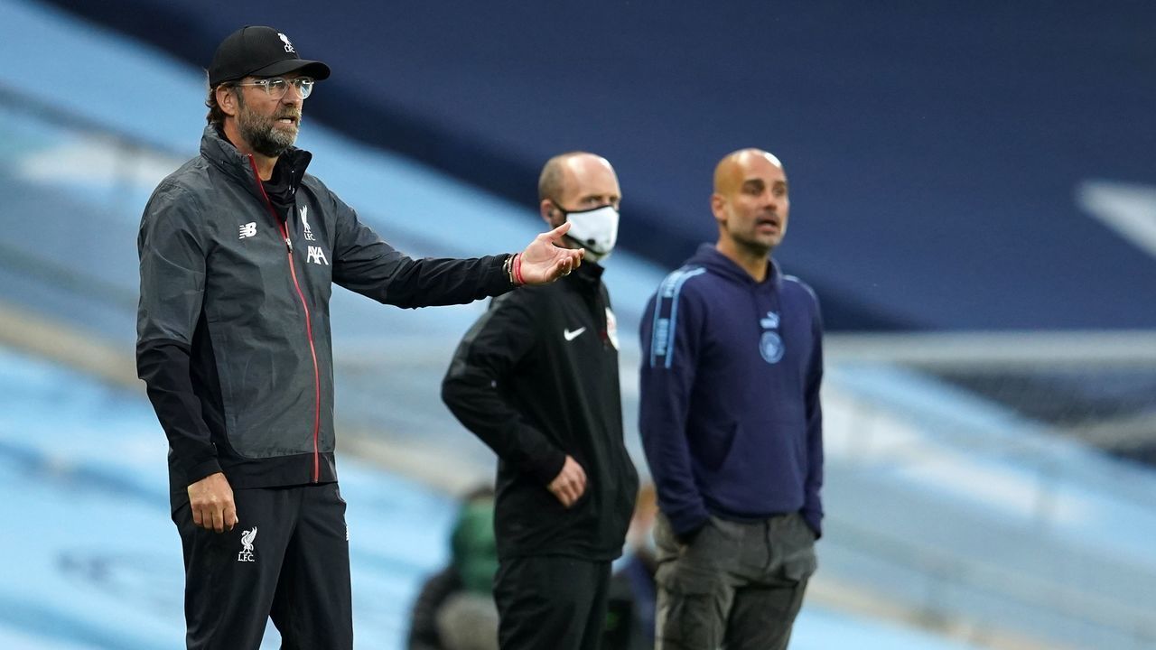 Liverpool's German manager Jurgen Klopp (L) reacts on the sidelines alongside Manchester City's Spanish manager Pep Guardiola (R) and fourth official Mike Dean (C) during the English Premier League football match between Manchester City and Liverpool at the Etihad Stadium in Manchester, north west England, on July 2, 2020.