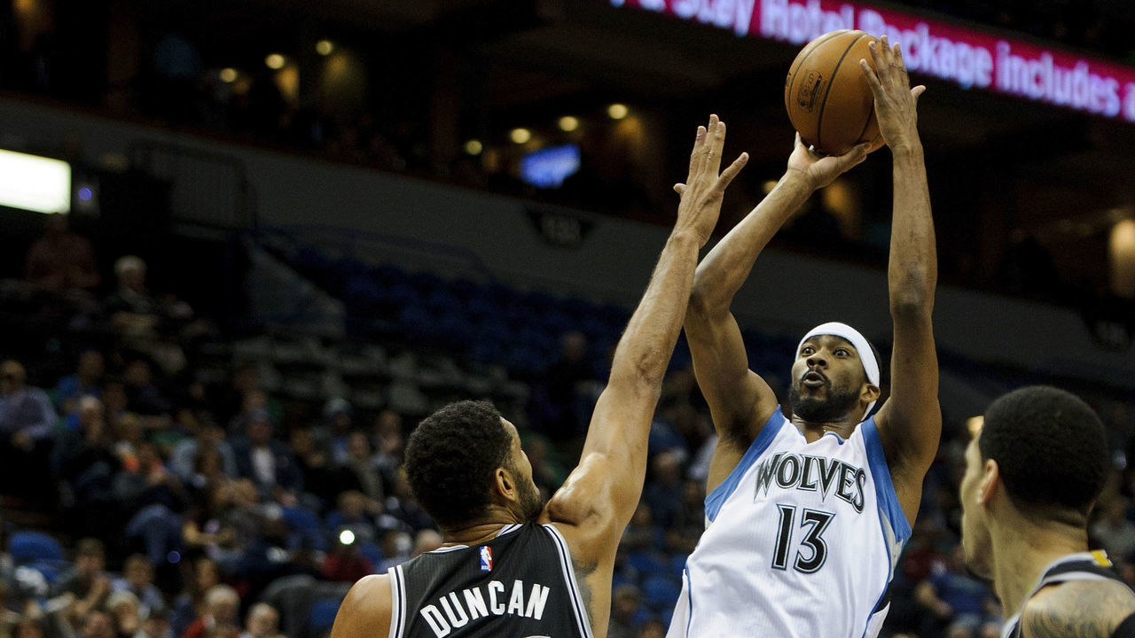 MINNEAPOLIS, MN - NOVEMBER 21: Corey Brewer #13 of the Minnesota Timberwolves shoots a basket against Tim Duncan #21 of the San Antonio Spurs during the game on November 21, 2014 at Target Center in Minneapolis, Minnesota. The Spurs defeated the Timberwolves 121-92.