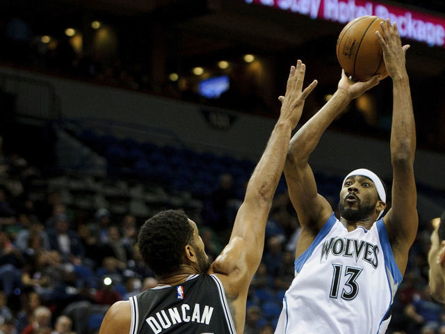 MINNEAPOLIS, MN - NOVEMBER 21: Corey Brewer #13 of the Minnesota Timberwolves shoots a basket against Tim Duncan #21 of the San Antonio Spurs during the game on November 21, 2014 at Target Center in Minneapolis, Minnesota. The Spurs defeated the Timberwolves 121-92.