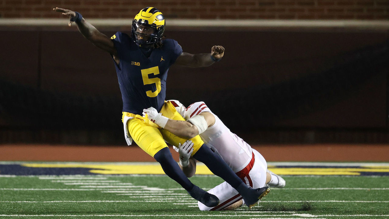 ANN ARBOR, MICHIGAN - NOVEMBER 14: Joe Milton #5 of the Michigan Wolverines tries to get a first half pass of while being tackled by Leo Chenal #45 of the Wisconsin Badgers at Michigan Stadium on November 14, 2020 in Ann Arbor, Michigan.