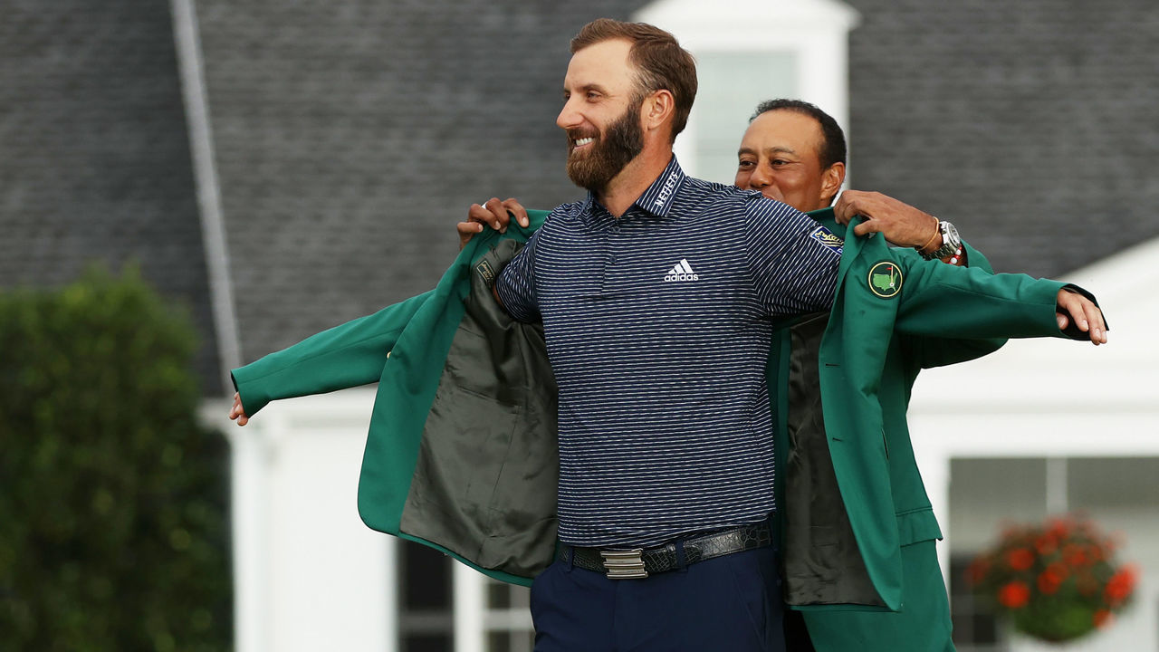 AUGUSTA, GEORGIA - NOVEMBER 15: Dustin Johnson of the United States is awarded the Green Jacket by Masters champion Tiger Woods of the United States during the Green Jacket Ceremony after winning the Masters at Augusta National Golf Club on November 15, 2020 in Augusta, Georgia.