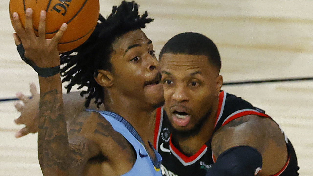 LAKE BUENA VISTA, FLORIDA - AUGUST 15: Ja Morant #12 of the Memphis Grizzlies goes drives past Damian Lillard #0 of the Portland Trail Blazers during the fourth quarter in the Western Conference play-in game one at The Field House at ESPN Wide World Of Sports Complex on August 15, 2020 in Lake Buena Vista, Florida.
