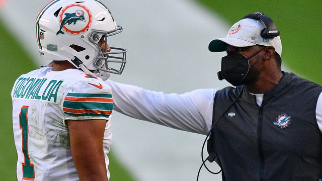 MIAMI GARDENS, FLORIDA - NOVEMBER 15: Head Coach Brian Flores of the Miami Dolphins speaks with Tua Tagovailoa #1 during the game against the Los Angeles Chargers at Hard Rock Stadium on November 15, 2020 in Miami Gardens, Florida.