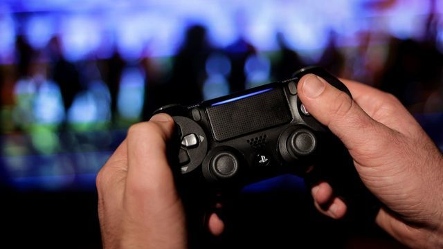 A gamer uses a PS4 controller as he plays at the new Ubisoft video game "Watch Dogs Legion" on October 28, 2020, in Brussels. - The new game released on Octoer 28, 2020, by French studio Ubisoft is set in a dystopian near-future London, haunted by authoritarian surveillance and the ghost of Brexit.