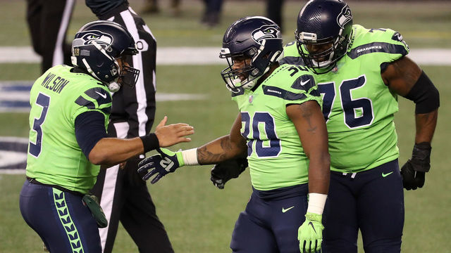 SEATTLE, WASHINGTON - NOVEMBER 19: Carlos Hyde #30 of the Seattle Seahawks is congratulated by Russell Wilson #3 after he ran in for a touchdown against the Arizona Cardinals in the third quarter at Lumen Field on November 19, 2020 in Seattle, Washington.