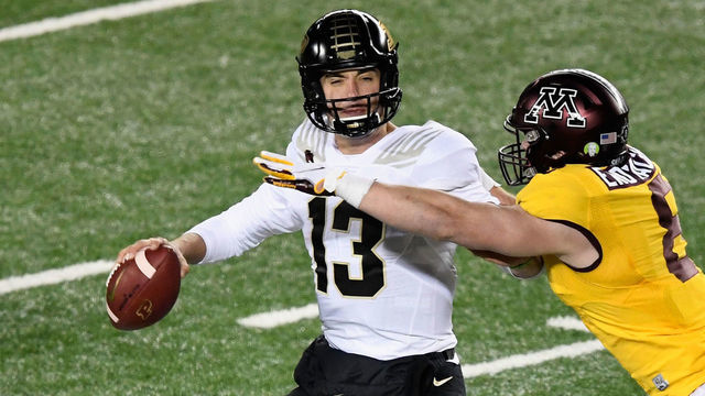 MINNEAPOLIS, MINNESOTA - NOVEMBER 20: Quarterback Jack Plummer #13 of the Purdue Boilermakers passes the ball under pressure from Thomas Rush #8 of the Minnesota Golden Gophers during the fourth quarterof the game at TCF Bank Stadium on November 20, 2020 in Minneapolis, Minnesota. The Golden Gophers defeated the Boilermakers 34-31.