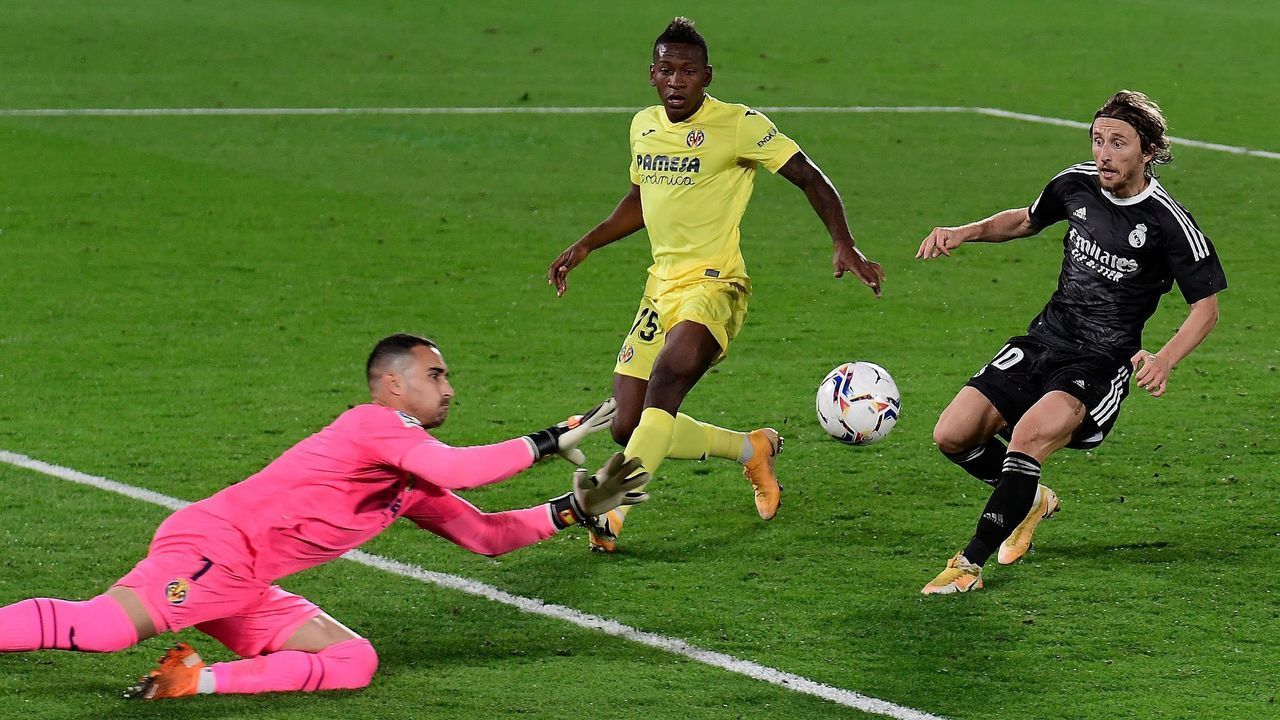 Villarreal's Spanish goalkeeper Sergio Asenjo (L) blocks a shot on goal by Real Madrid's Croatian midfielder Luka Modric (R) next to Villarreal's Ecuadorian defender Pervis Estupinan (C) during the Spanish League football match between Villarreal and Real Madrid at La Ceramica stadium in Vila-real on November 21, 2020.