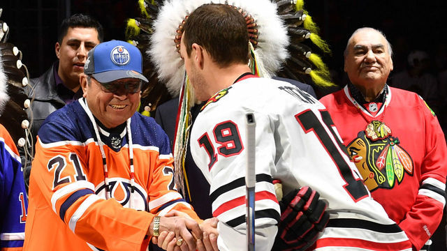 EDMONTON, AB - DECEMBER 29: Jonathan Toews #19 of the Chicago Blackhawks greets Fred Sasakamoose prior to the game against the Edmonton Oilers on December 29, 2017 at Rogers Place in Edmonton, Alberta, Canada.