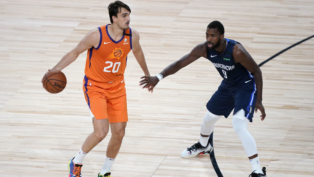 LAKE BUENA VISTA, FLORIDA - AUGUST 13: Dario Saric #20 of the Phoenix Suns brings the ball up court against Michael Kidd-Gilchrist #9 of the Dallas Mavericks in the second half at AdventHealth Arena at ESPN Wide World Of Sports Complex on August 13, 2020 in Lake Buena Vista, Florida.