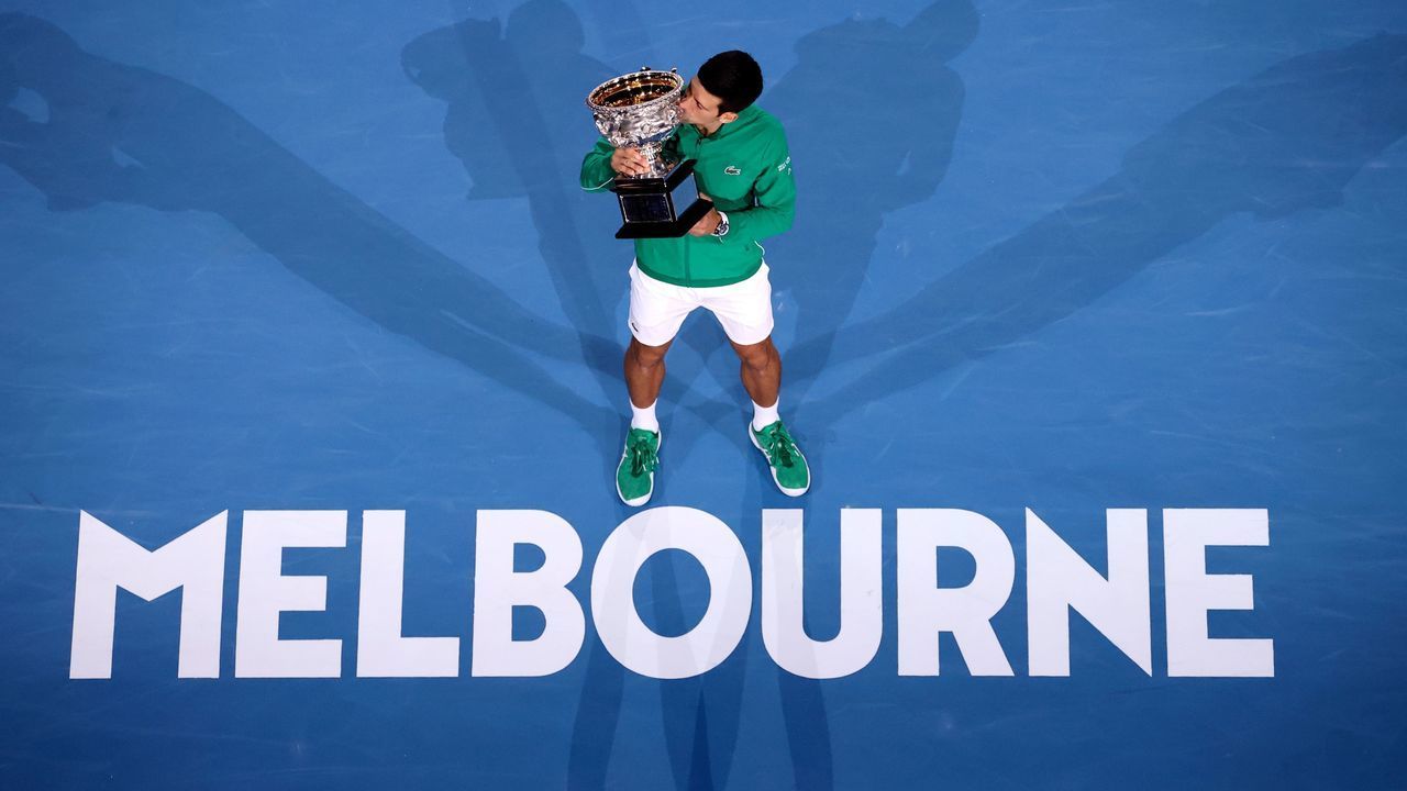 Serbia's Novak Djokovic kisses the Norman Brooks Challenge Cup trophy after winning against Austria's Dominic Thiem in their men's singles final match on day fourteen of the Australian Open tennis tournament in Melbourne on February 3, 2020.