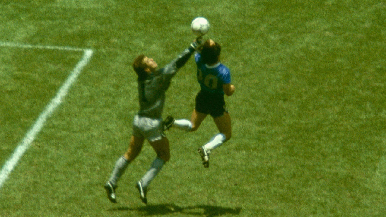 MEXICO CITY, MEXICO - JUNE 22: Argentina player Diego Maradona outjumps England goalkeeper Peter Shilton to score with his 'Hand of God' goal as England defenders Kenny Sansom (top) Gary Stevens (c) and Terry Fenwick look on during the 1986 FIFA World Cup Quarter Final at the Azteca Stadium on June 22, 1986 in Mexico City, Mexico.