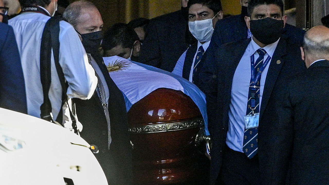 The coffin carrying the remains of the late Argentinian football legend Diego Armando Maradona is carried out from the Casa Rosada government house, in Buenos Aires, on November 26, 2020. - Argentine football legend Diego Maradona -who died of a heart attack on the eve, at the age of 60- will be laid to rest in the Jardin de Paz cemetery on the outskirts of Buenos Aires, where his parents were also buried, Sebastian Sanchi told AFP.